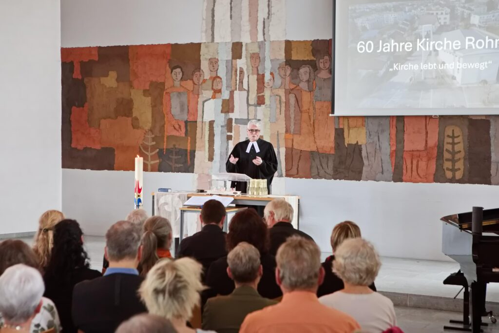Pfarrer am Rednerpult in der Kirche mit vielen Zuschauern
